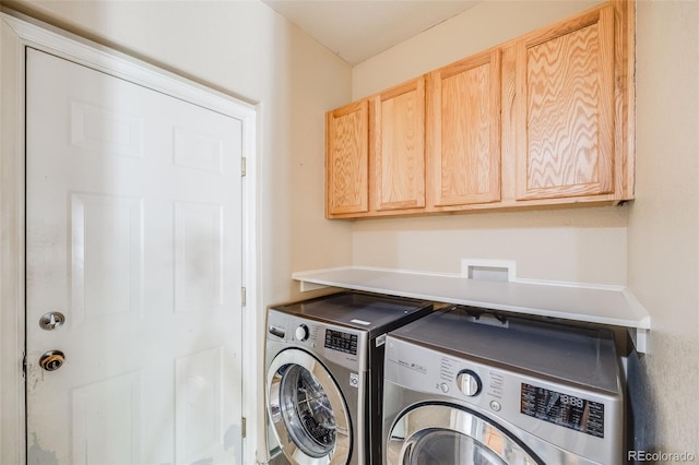 washroom featuring washing machine and dryer and cabinet space