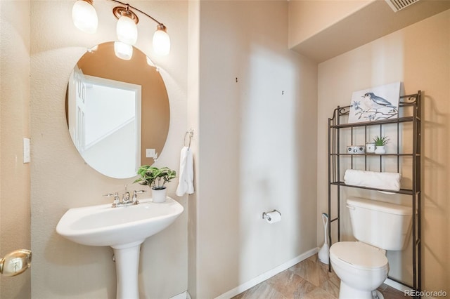 half bathroom featuring toilet and baseboards