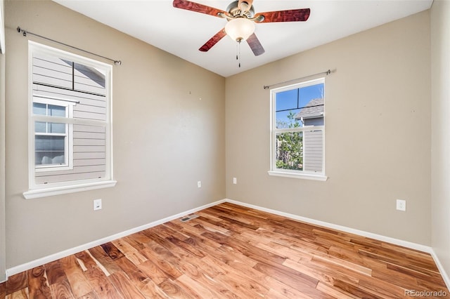 unfurnished room with wood finished floors, baseboards, and a ceiling fan