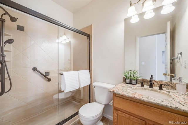 bathroom with vanity, toilet, and a shower stall