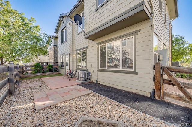 back of house with cooling unit, a patio, a fenced backyard, and a gate