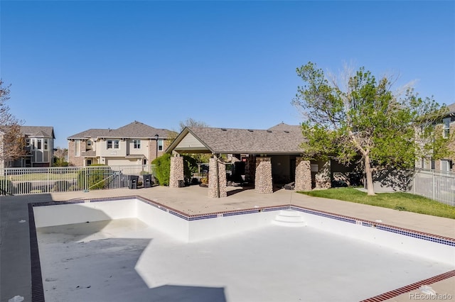 view of swimming pool featuring a residential view, fence, and a patio area