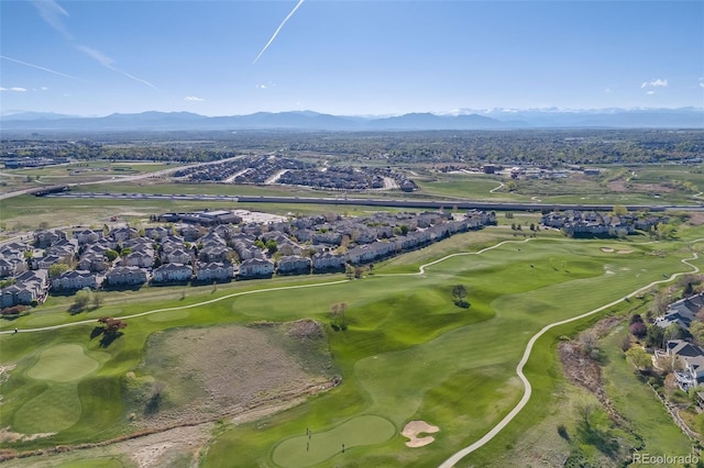aerial view of property's location with mountains, a golf course, and nearby suburban area