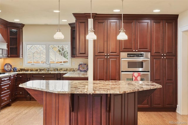 2006 N Cascade Ave, Colorado Springs, CO 80907 - kitchen featuring light stone counters, double oven, light wood finished floors, glass insert cabinets, and recessed lighting