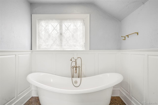2006 N Cascade Ave, Colorado Springs, CO 80907 - bathroom with a freestanding bath, a wainscoted wall, vaulted ceiling, and a decorative wall