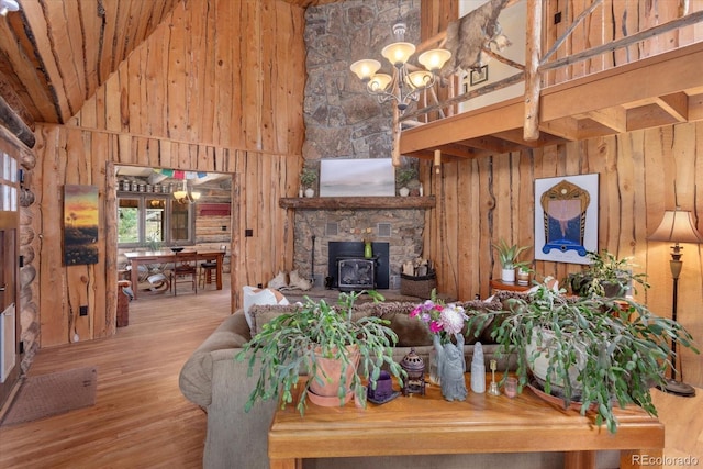 18680 Wapiti Cir, Buena Vista, CO 81211 - living area with high vaulted ceiling, wood walls, a wood stove, wood finished floors, and a chandelier