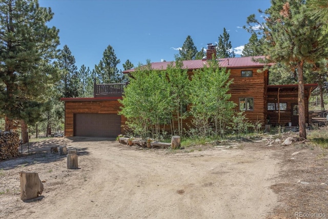 18680 Wapiti Cir, Buena Vista, CO 81211 - view of front of property featuring a chimney, driveway, an attached garage, and a metal roof