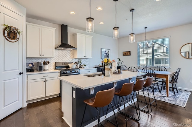 21038 E Quincy Pl, Aurora, CO 80015 - kitchen with wall chimney exhaust hood, stainless steel gas range oven, recessed lighting, dark wood finished floors, and tasteful backsplash