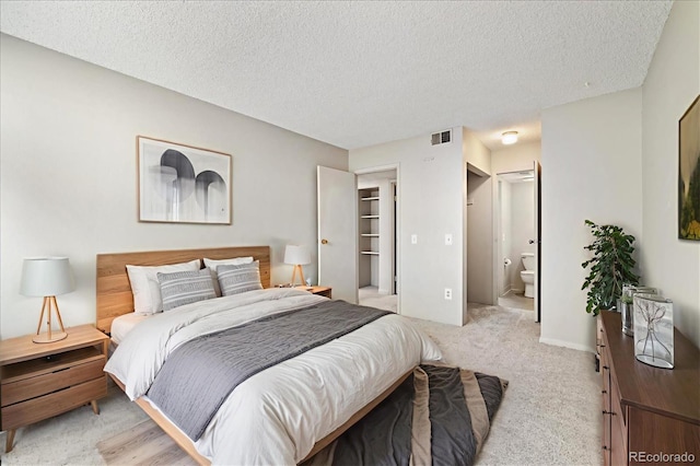 15202 E Hampden Cir Unit F2, Aurora, CO 80014 - bedroom with a textured ceiling, light colored carpet, and ensuite bathroom