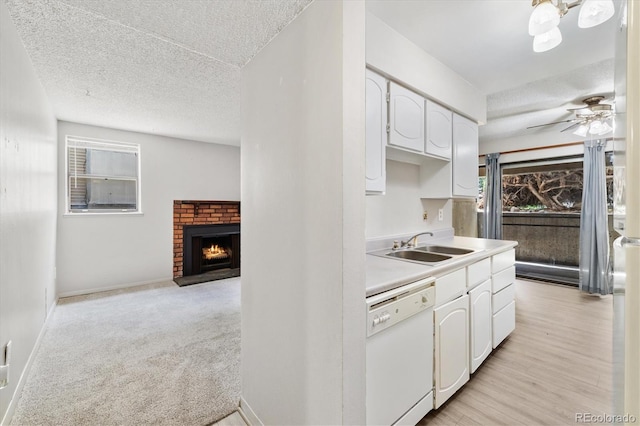 15202 E Hampden Cir Unit F2, Aurora, CO 80014 - kitchen with dishwasher, a brick fireplace, white cabinetry, a ceiling fan, and light countertops