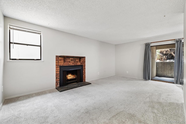 15202 E Hampden Cir Unit F2, Aurora, CO 80014 - unfurnished living room with healthy amount of natural light, carpet, a textured ceiling, and a fireplace