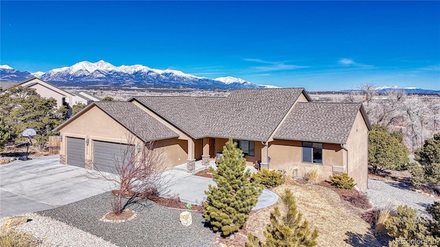 ranch-style house featuring a mountain view, stucco siding, and an attached garage