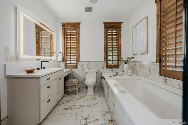 1332 S Lafayette St, Denver, CO 80210 - full bathroom with vanity, toilet, a garden tub, marble finish flooring, and tile walls