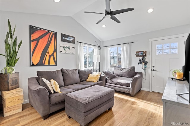 living room with ceiling fan, light hardwood / wood-style flooring, and vaulted ceiling