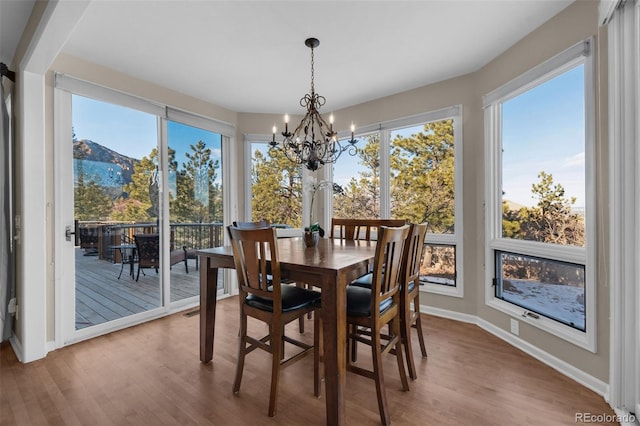 dining space with a notable chandelier, wood-type flooring, and a mountain view