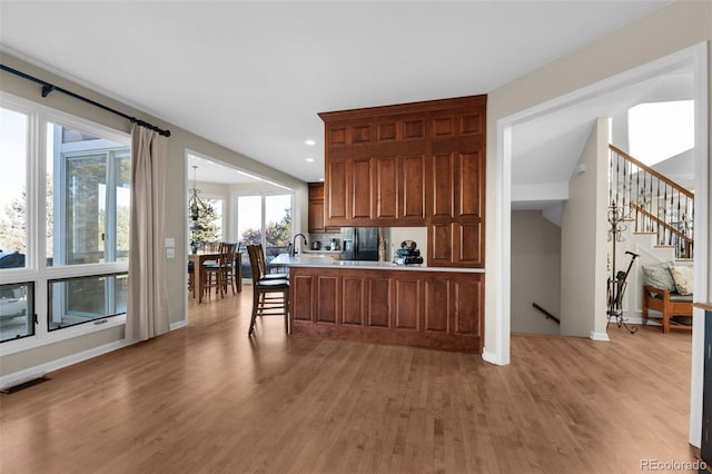 kitchen with kitchen peninsula and light wood-type flooring