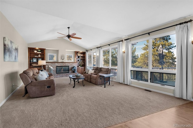 living room featuring ceiling fan, lofted ceiling, hardwood / wood-style floors, and a fireplace