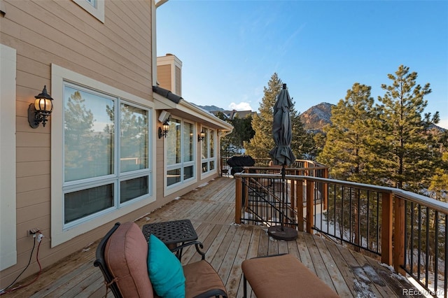 wooden deck with area for grilling and a mountain view