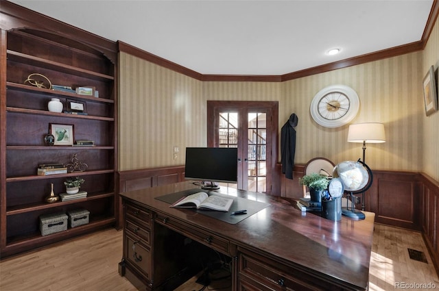 home office featuring french doors, ornamental molding, built in shelves, and light hardwood / wood-style flooring