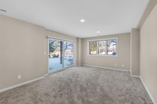 empty room with a wealth of natural light and light colored carpet