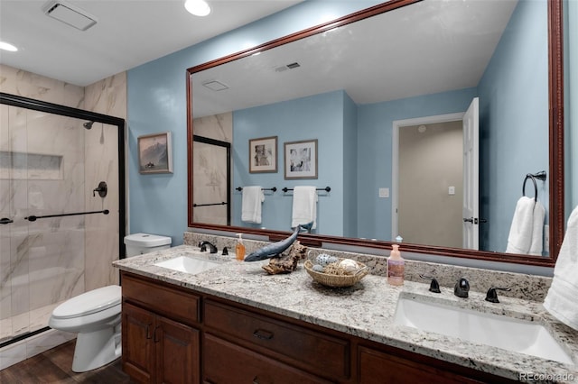 bathroom featuring a shower with door, wood-type flooring, vanity, and toilet