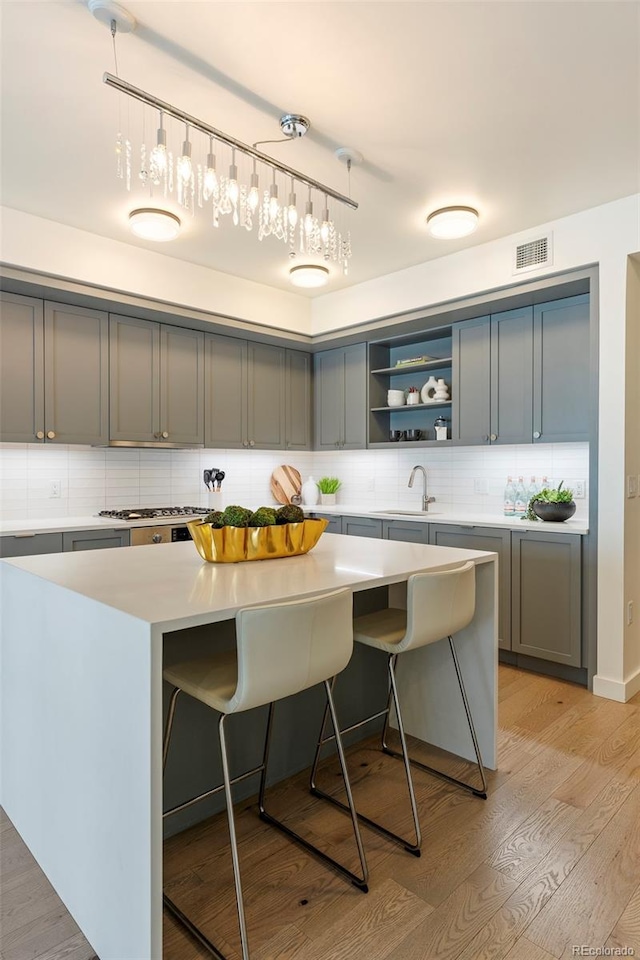1750 Wewatta St Unit 809, Denver, CO 80202 - kitchen featuring a kitchen bar, a sink, tasteful backsplash, light countertops, and a kitchen island