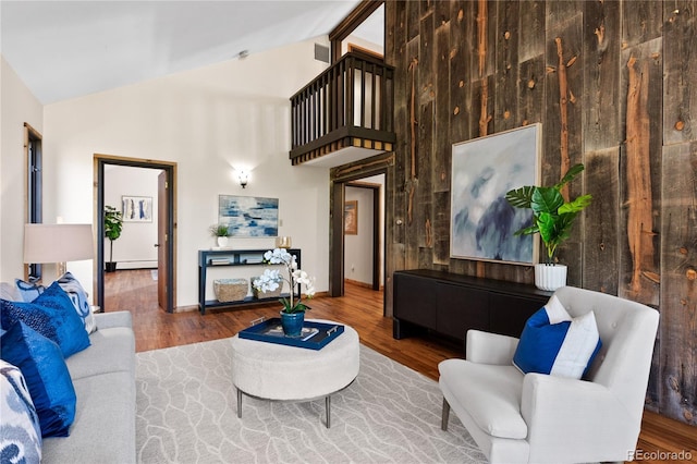 living room with hardwood / wood-style flooring and high vaulted ceiling