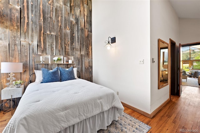 bedroom featuring hardwood / wood-style floors and high vaulted ceiling