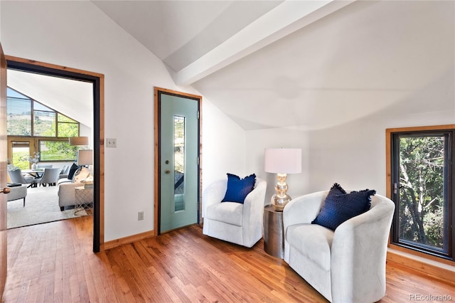 sitting room with vaulted ceiling with beams, plenty of natural light, and hardwood / wood-style floors