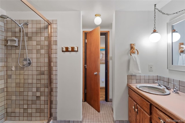 bathroom featuring tile patterned flooring, a shower with shower door, and vanity