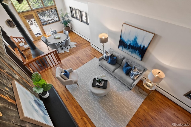 living room with a baseboard heating unit and hardwood / wood-style flooring