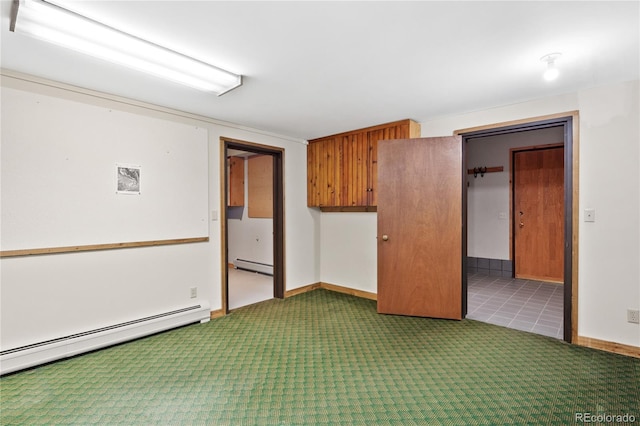 carpeted spare room featuring a baseboard heating unit