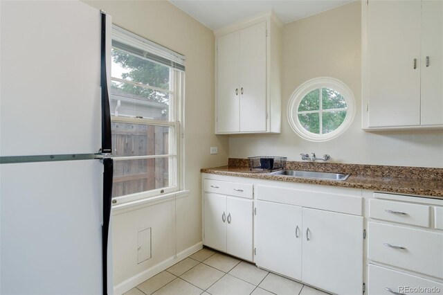 kitchen with sink, white cabinets, and light tile patterned flooring