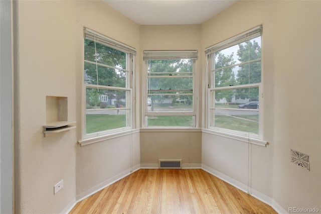 unfurnished room featuring light hardwood / wood-style flooring and plenty of natural light