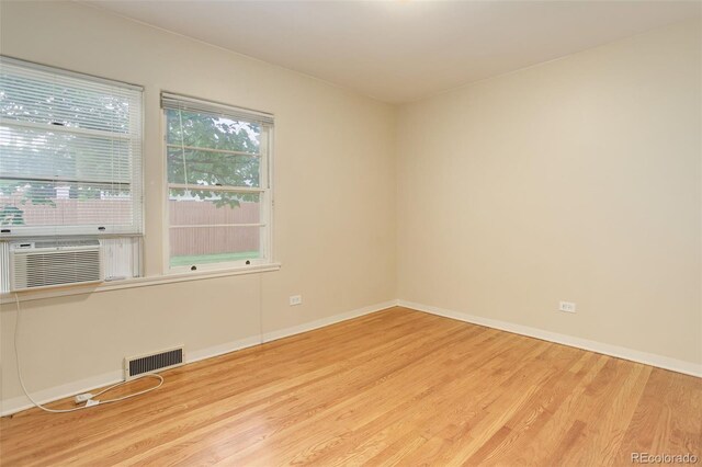 spare room featuring cooling unit and light hardwood / wood-style flooring