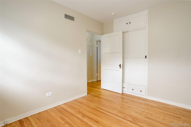 unfurnished bedroom with a closet and light hardwood / wood-style flooring