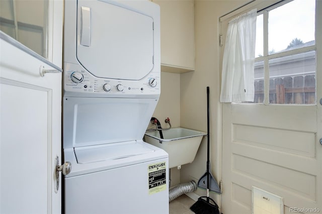 laundry area featuring sink and stacked washer / drying machine