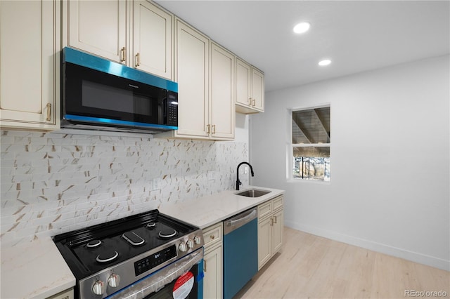 kitchen featuring cream cabinetry, appliances with stainless steel finishes, and sink