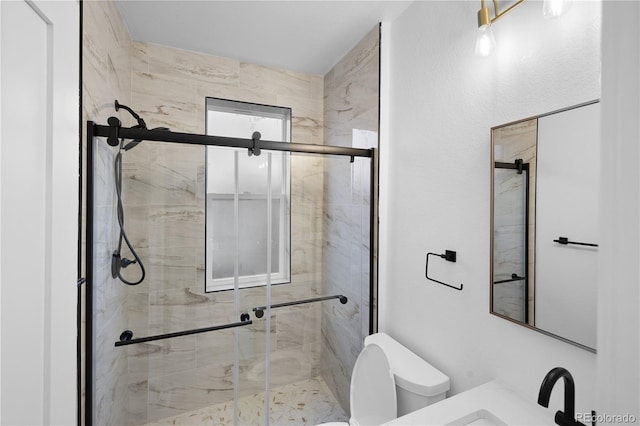 bathroom with toilet, a shower with shower door, and sink