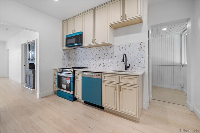 2207 E 25th, Denver, CO 80205 - kitchen featuring dishwashing machine, stainless steel range, cream cabinetry, a sink, and black microwave