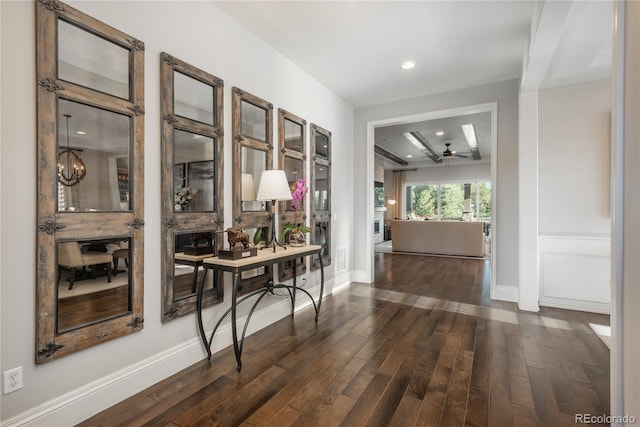 hallway with a notable chandelier and dark hardwood / wood-style flooring