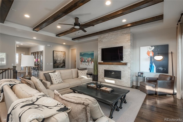 living room featuring dark hardwood / wood-style floors, a fireplace, and beamed ceiling