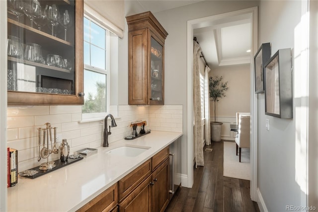 bar featuring dark hardwood / wood-style flooring, sink, tasteful backsplash, and ornamental molding