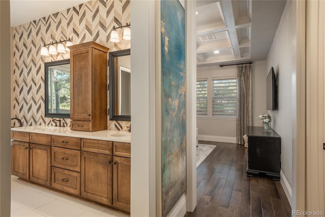 bathroom with beamed ceiling, vanity, coffered ceiling, and a wealth of natural light