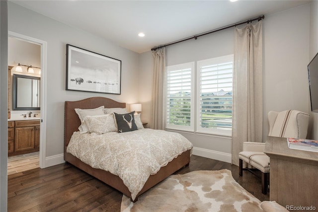 bedroom featuring dark hardwood / wood-style flooring, sink, and ensuite bathroom