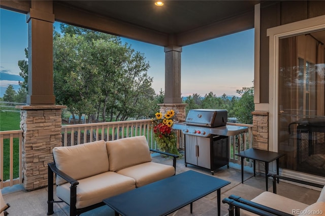 patio terrace at dusk featuring an outdoor living space and grilling area