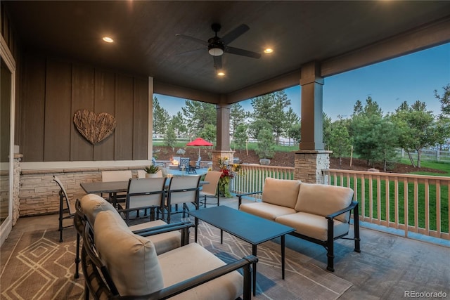 patio terrace at dusk featuring an outdoor living space and ceiling fan