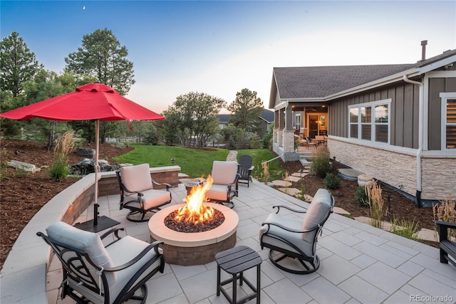 patio terrace at dusk featuring an outdoor fire pit