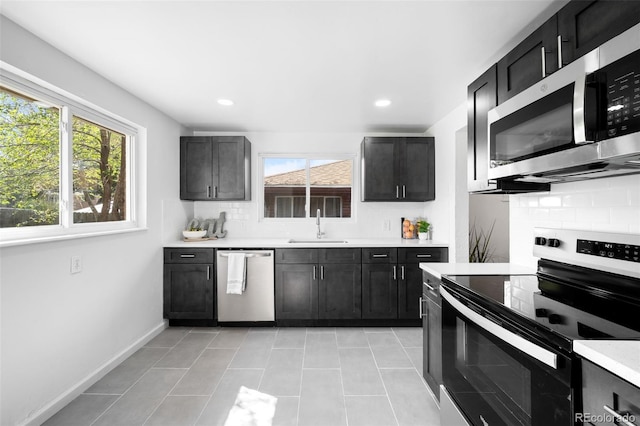 1148 N Clinton St, Aurora, CO 80010 - kitchen with appliances with stainless steel finishes, a sink, tasteful backsplash, light countertops, and light tile patterned floors