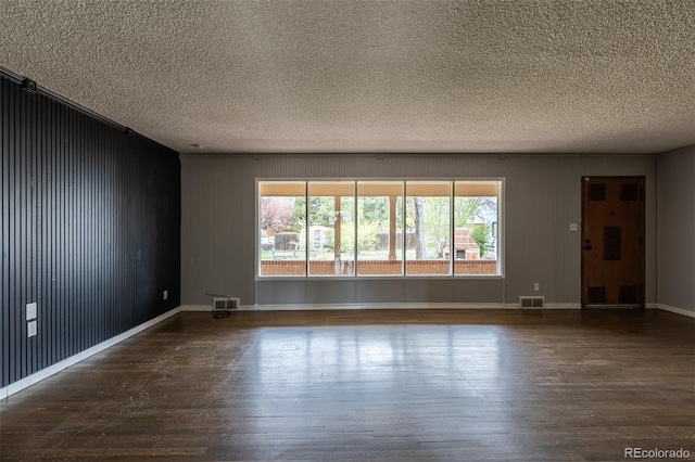 1345 Laredo St, Aurora, CO 80011 - spare room with a textured ceiling, plenty of natural light, visible vents, and wood finished floors